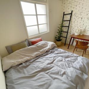 a bed in a room with a window and a table at 山蒔旁白-全台唯一電力公司48年老宿舍改造 in Yujing