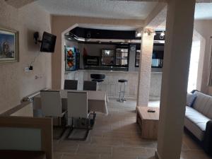 a living room with a table and chairs and a couch at Kazablanka Rooms Aerodrom in Podgorica