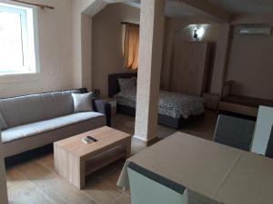 een woonkamer met een bank en een bed bij Kazablanka Rooms Aerodrom in Podgorica