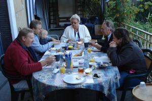 a group of people sitting at a table eating food at Chambres d'hôtes Notre Paradis in Dun-sur-Meuse