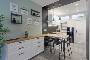 a kitchen with a table and chairs and a refrigerator at Centre-ville - Fibre - Netflix - T2 L'ISAC in Blain +12 photos