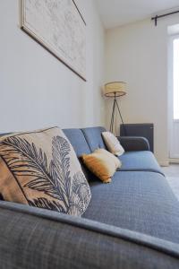 a blue bed with pillows on it in a room at Centre-ville - Fibre - Netflix - T2 L'ISAC in Blain