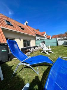 2 chaises de jardin bleues dans la cour d'une maison dans l'établissement WISSANT maison 6 personnes tout confort, à Wissant