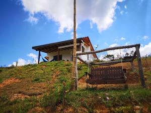 a swing on top of a hill with a house at Villa Namaste - Cabaña Excélsior in Curití