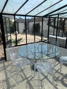 a glass table and chairs on a patio at Beach Cottage in Le Bois-Plage-en-Ré