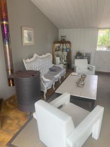 uma sala de estar com mobiliário branco e uma mesa em Beach Cottage em Le Bois-Plage-en-Ré