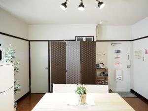 a dining room with a table and a kitchen at Living CUBE Beppu Station / Vacation STAY 54926 in Beppu