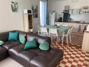 een woonkamer met een leren bank en een tafel bij Au Soleil Vert in Mont-Bernenchon