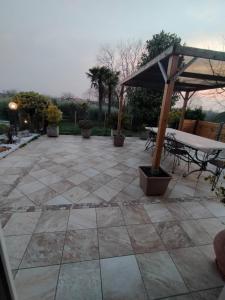 eine Terrasse mit einem Tisch und einem Sonnenschirm in der Unterkunft B&B Il Tramonto in Pastrengo