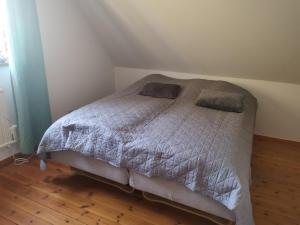 a bed in a bedroom with a wooden floor at Gotland, Hästgård i Stånga in Stånga