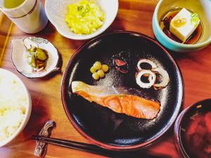 a plate of food with a fish on a table at Amanohashidate Youth Hostel in Miyazu