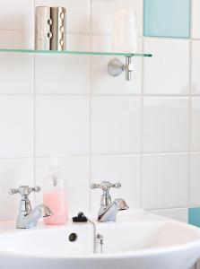 a white bathroom sink with two faucets at Tor Dean Guest House in Torquay