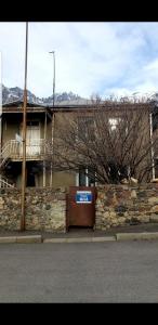 a brick building with a door with a sign on it at Guest House Dodo in Stepantsminda