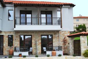 a house with a balcony and patio at IADES suites in Afitos
