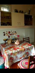 a dining room table with a flowered table cloth on it at Guest House Dodo in Stepantsminda
