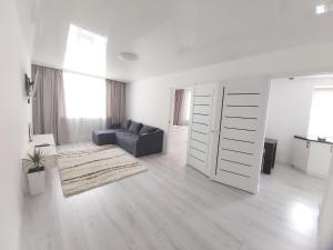 sala de estar blanca con sofá y puerta corredera en 2-х комнатная квартира, en Taraz