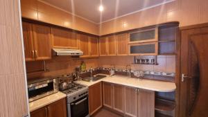 a kitchen with wooden cabinets and a stove top oven at Cosy appartment in Tashkent