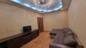 sala de estar con sofá y TV en Cosy appartment en Tashkent