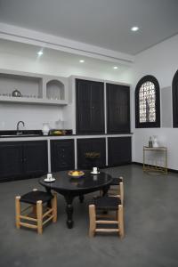 a kitchen with a table and two chairs and a counter at Dar Yomma in Tozeur