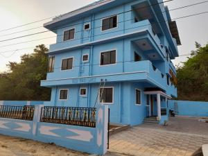 a blue building with a fence in front of it at Shanaya Holiday Apartment in Benaulim