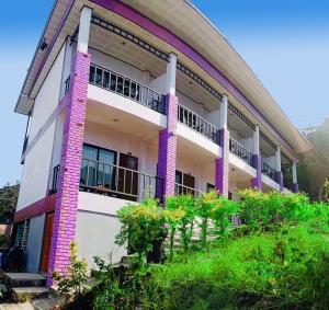 un edificio con columnas púrpuras y balcones en View Garden Resort, en Islas Phi Phi