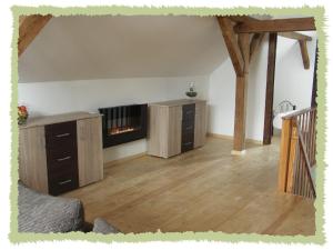 sala de estar con chimenea y suelo de madera. en Ferienwohnung zum Bernerhof en Lindenberg