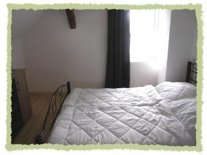 1 dormitorio con 1 cama con sábanas blancas y ventana en Ferienwohnung zum Bernerhof en Lindenberg