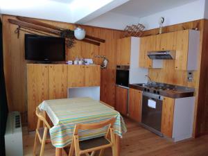 a kitchen with a table and a stove and a sink at Marilleva1400 Residence Albaré hotel Solaria in Marilleva +31 photos