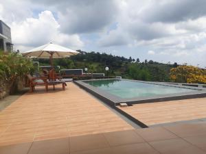 uma piscina com uma mesa e um guarda-sol em RD Cottage Hills em Cihideung