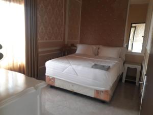 um quarto com uma cama grande num quarto em RD Cottage Hills em Cihideung