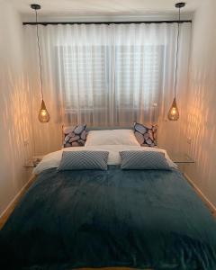 a large bed in a bedroom with two lights at Mittendrin Ortenau -keine Monteurwohnung- in Kehl am Rhein