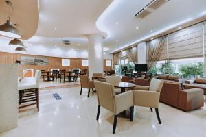 un vestíbulo de un hotel con mesas y sillas en Athinaiko Hotel en Heraclión