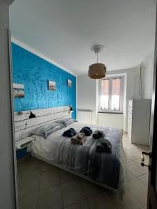 1 dormitorio con 1 cama grande y pared azul en Civico69 en Rapallo