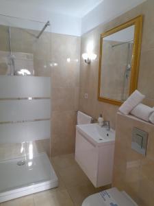 a bathroom with a sink and a toilet and a mirror at Apartments - Villa Sabrina in Brela