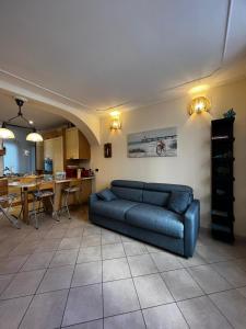 a living room with a blue couch and a kitchen at Civico69 in Rapallo