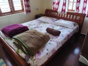 a bed with blankets and pillows on it at Hidden gem home stay in Madikeri
