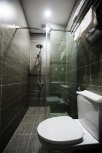 a bathroom with a toilet and a glass shower at The White House in Ho Chi Minh City