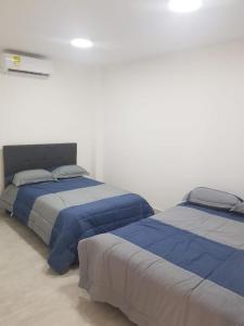 2 Betten nebeneinander in einem Zimmer in der Unterkunft Cabaña pescador de colores in Coveñas