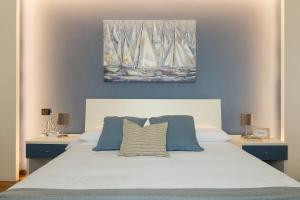1 dormitorio con 1 cama blanca grande y 2 mesitas de noche en Le 2 Perle 2.0 en Peschiera del Garda