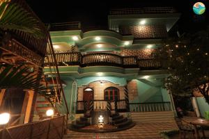 een huis 's nachts met een trap ervoor bij Tropical Wave Hostel Morjim in Morjim