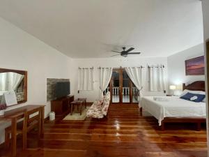 Agoho Resort في مامباجاو: غرفة نوم بسرير ومروحة سقف