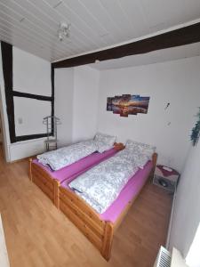 een slaapkamer met een houten bed met paarse lakens bij Große rustikale Ferienwohnung am Stadtrand von Röbel an der Müritz mit Balkon in Röbel