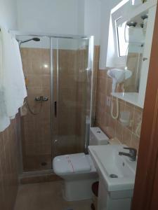 e bagno con doccia, servizi igienici e lavandino. di Anna Maria Apartments a Kardámaina