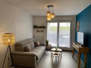 a living room with a couch and a tv at Bel Appartement lumineux à 5 minutes d'Annecy in Seynod