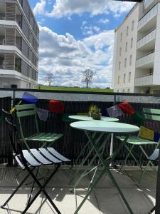 stół i krzesła na balkonie ze stołem w obiekcie Bel Appartement lumineux à 5 minutes d'Annecy w mieście Seynod