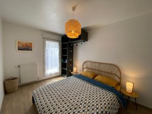 a bedroom with a bed and a window and a lamp at Bel Appartement lumineux à 5 minutes d'Annecy in Seynod