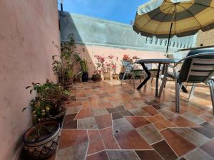 un patio con mesa, sillas y sombrilla en Riad 112, en Marrakech
