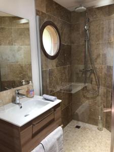 La salle de bains est pourvue d'un lavabo et d'une douche. dans l'établissement Chambres & Tables d'Hôtes L'Ostal de Pombonne, à Bergerac