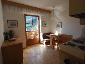 eine Küche und ein Esszimmer mit einem Tisch und einem Fenster in der Unterkunft Apartment zur schönen Aussicht in Algund