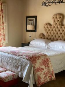 a hotel room with a bed, chair, and nightstand at Relais Sant'Elena in Bibbona